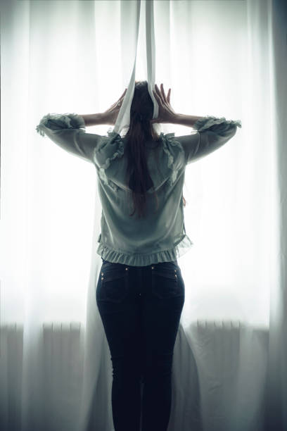 istock women silhouette at window 670140634