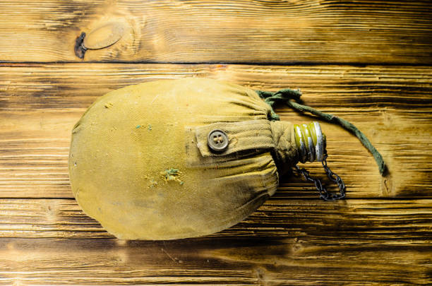 army flask in rag cover on wooden table - water bottle survival military bottle imagens e fotografias de stock