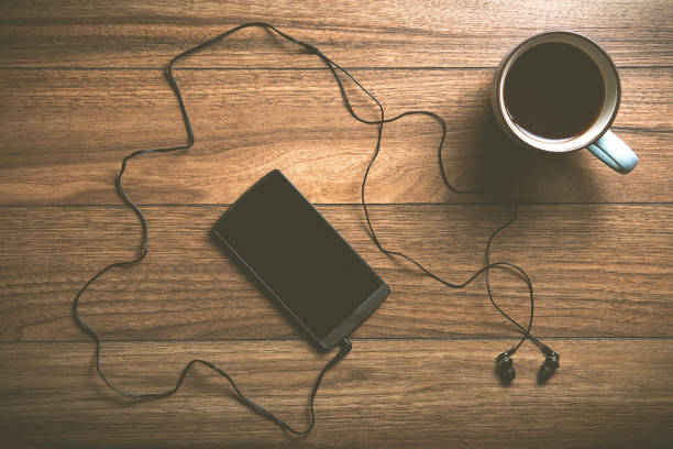 istock Phone with headphones and coffee on wood 670147278