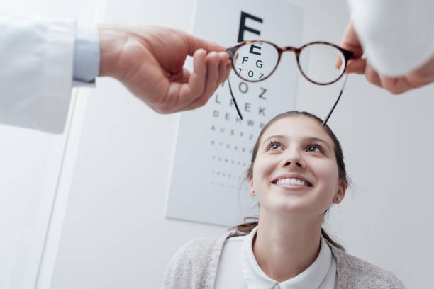 幸せな女性は彼女の新しいメガネを試して - patient happiness cheerful optometrist ストックフォトと画像