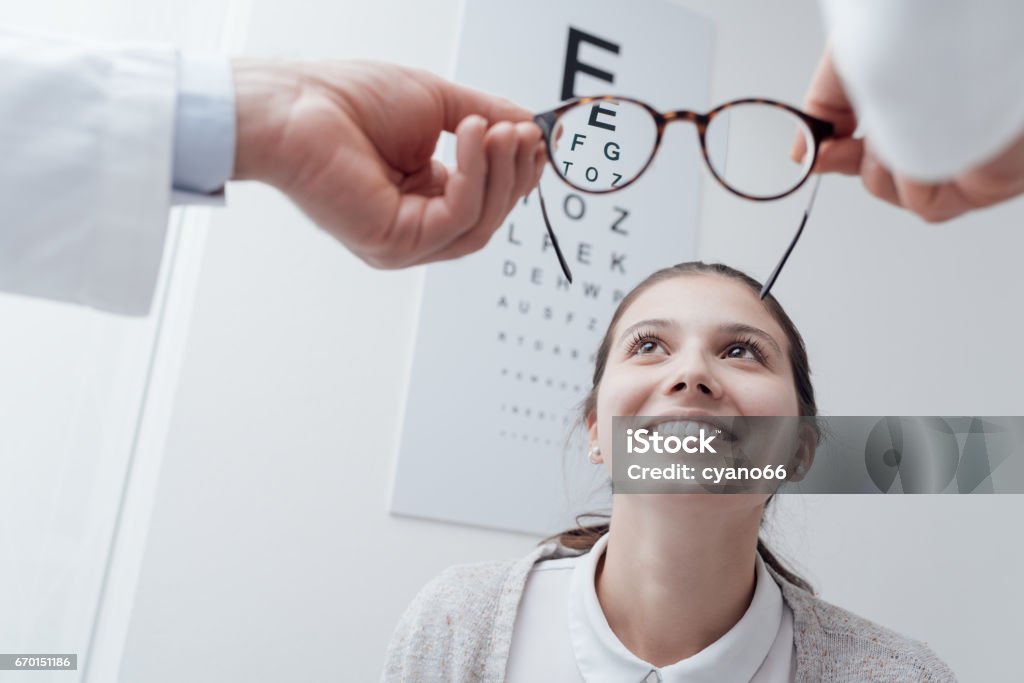 Happy woman trying her new glasses Young happy woman trying her new pair of glasses after the eye exam Myopia Stock Photo