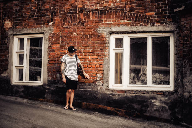 istock Attractive guy in a cap next to a brick wall 670170160