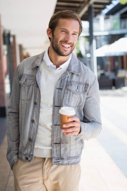 istock Young happy smiling man holding a a cup of coffee 670183922