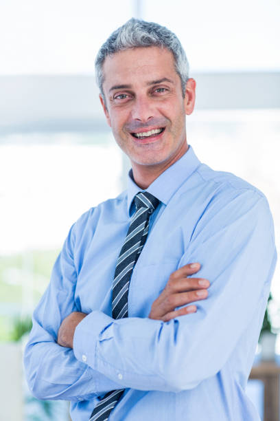istock Businessman looking at camera with arms crossed 670184592