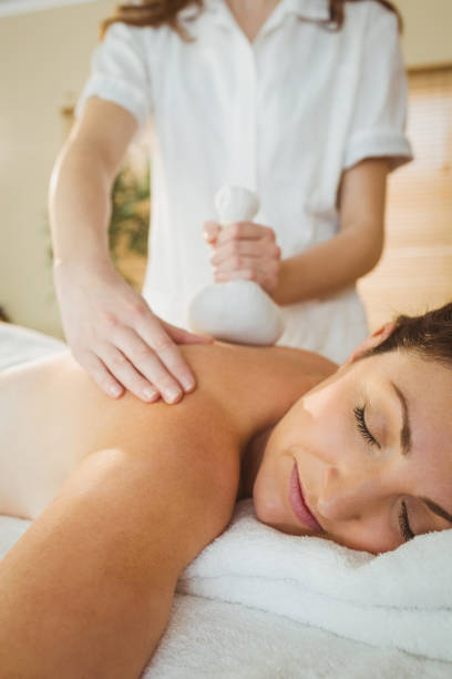 istock Young woman getting herbal compress massage 670187128