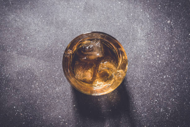 istock Glass of whiskey on gray stone background. 670196062