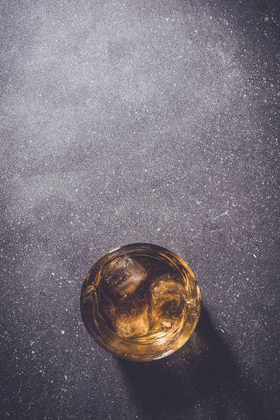 istock Glass of whiskey on gray stone background. 670202042