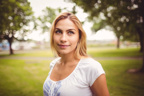 istock Smiling woman standing in park 670203504