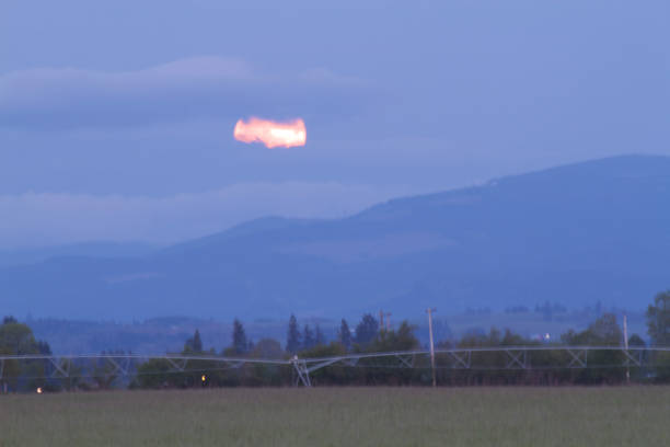 istock super moon shrouded by clouds at dusk 670209494