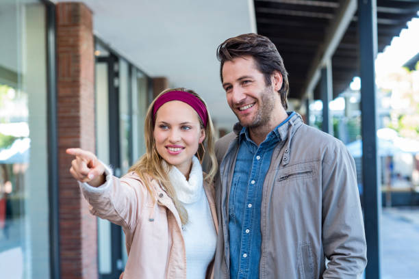 istock Smiling couple looking and pointing 670216744