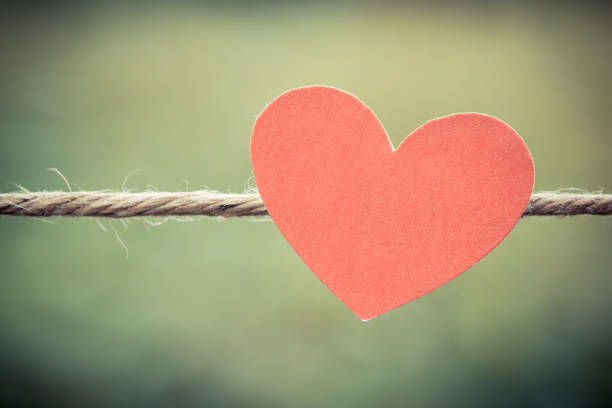 istock red paper hearts hanging on the Natural background. 670224320