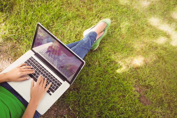 istock Low section of woman using laptop in park 670225800