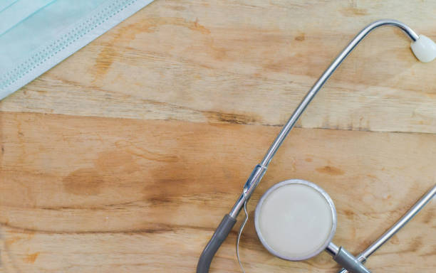 istock Mask, old stethoscope on wooden table 670228216