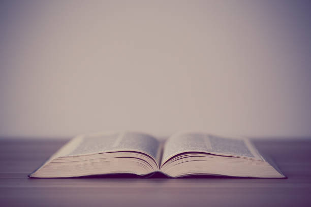 istock An opened holy bible on a wooden table 670235756