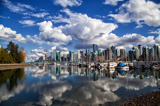 Vancouver skyline reflection, Canada Vancouver skyline reflection in Stanley park on a sunny Spring afternoon. shadow british columbia landscape cloudscape stock pictures, royalty-free photos & images