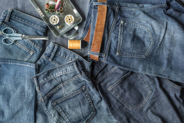 istock Top View of Jeans and Sewing Tools with on Blue Fabric Background 670243444