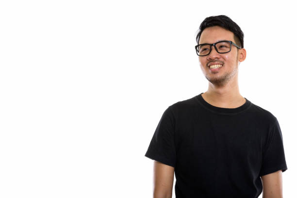 istock Studio shot of young happy Asian man smiling while thinking and wearing eyeglasses 670246876