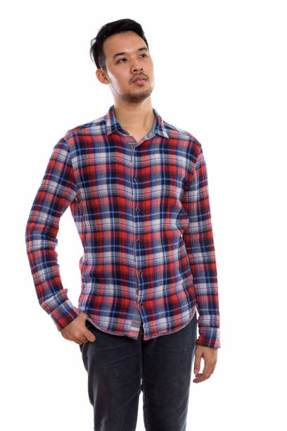 istock Studio shot of young Asian man standing while thinking 670247134