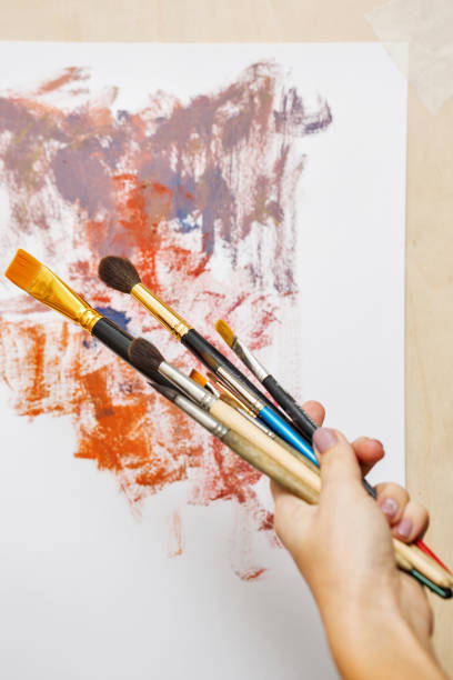 istock Hand of the artist with brushes 670247818