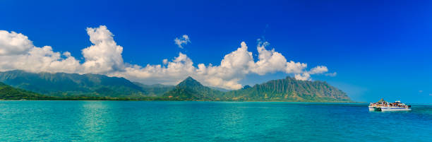 panoramia der tropischen lagune, üppigen bergen, einem katamaran und dem ozean in oahu, hawaii - honolulu oahu vacations park stock-fotos und bilder