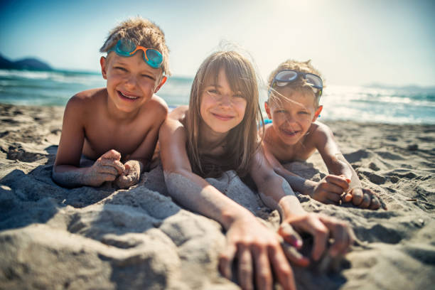 istock Kids lying on sandy beach of mediterranean sea. 670266870