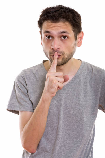istock Studio shot of young man with finger on lips 670271586