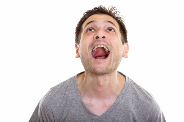 istock Studio shot of surprised happy young man smiling and looking up while opening mouth 670272144