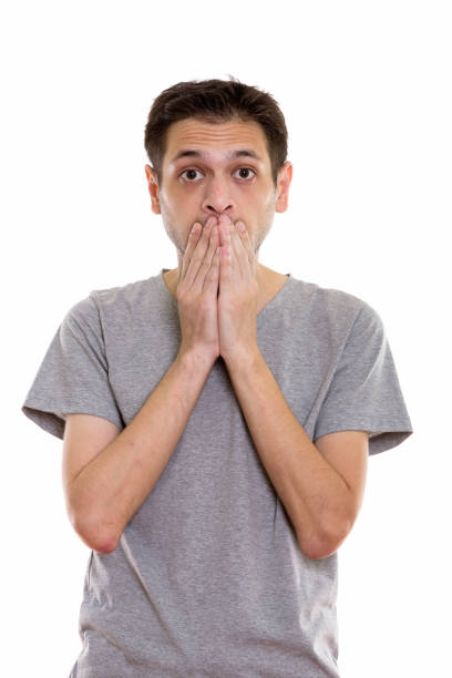 istock Studio shot of young man looking shocked while covering mouth 670272222