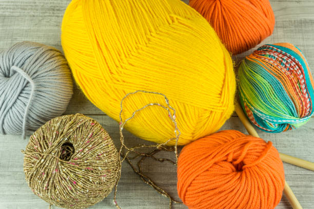 istock Wool balls in different colors with knitting needles on a wooden table 670273852