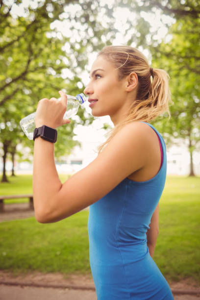 istock Smiling jogger woman drinking water 670274186