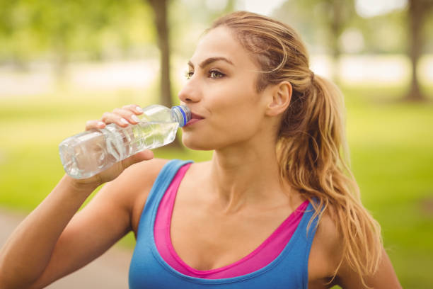 istock Woman drinking water in park 670274284