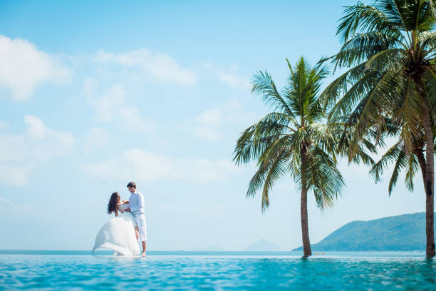 럭셔리 리조트에서 결혼식 후 신혼된 부부입니다. 로맨틱 신부 및 신랑 수영장 근처 편안한 허니문입니다. - wedding beach honeymoon bride 뉴스 사진 이미지