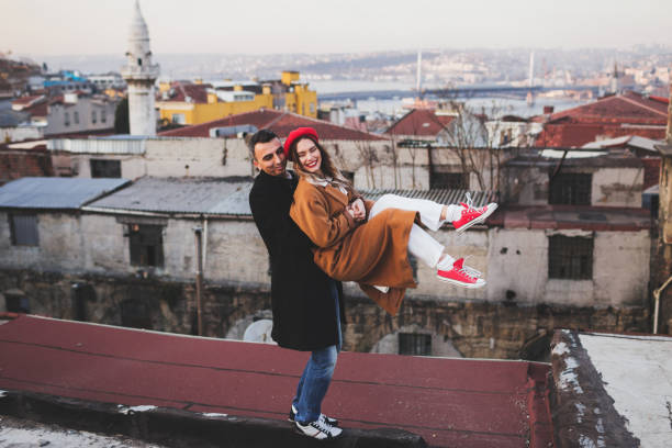 funny stylish couple having fun on roof. red beret and beige coat - sexual issues sexual activity couple tan imagens e fotografias de stock
