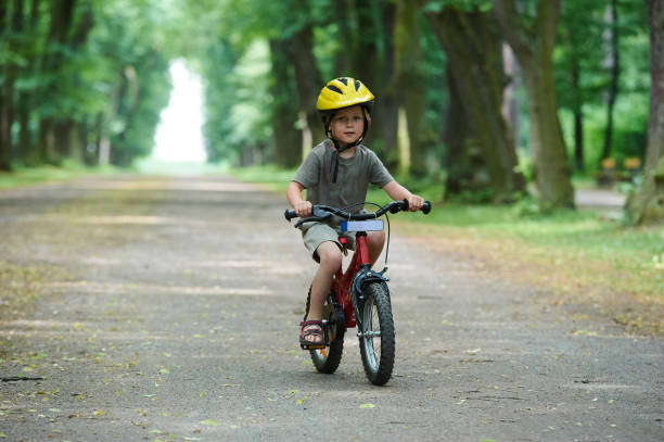 istock Child boy on a bicycle in the forest in summer. 670291472