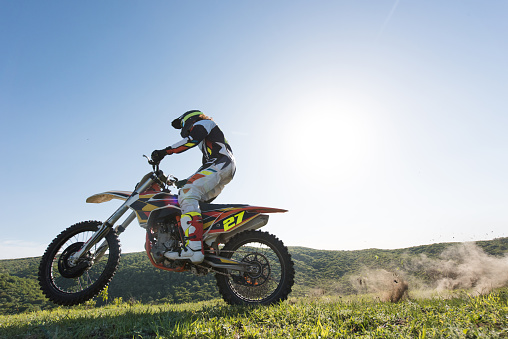 Low angle view of motocross rider racing in nature against the sky.