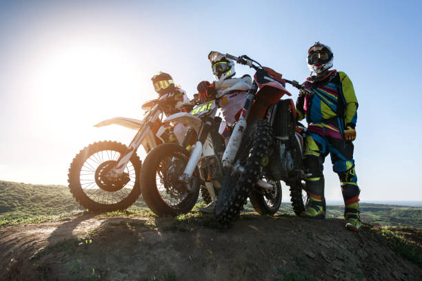 istock Below view of three motocross riders on dirt bikes. 670307768
