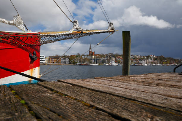 Flensburg Harbor, Germany Historic sailing boat at the harbor of Flensburg, Germany. Dramatic clouds in April. Photography taken with polarizing filter. gewitter stock pictures, royalty-free photos & images