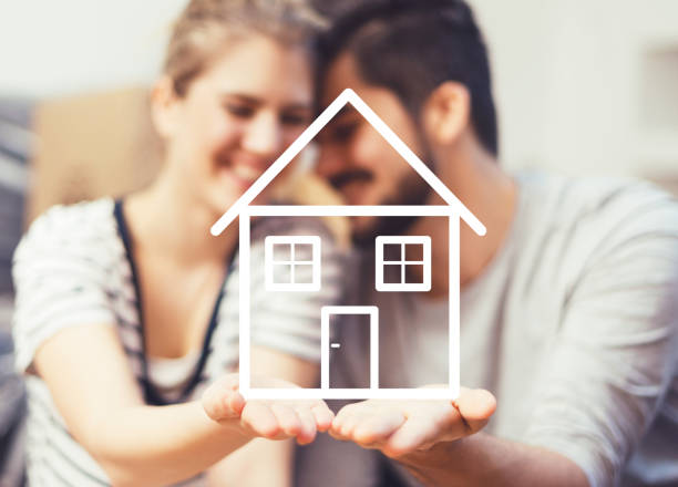 istock Young couple holding their new, dream home in hands 670310208