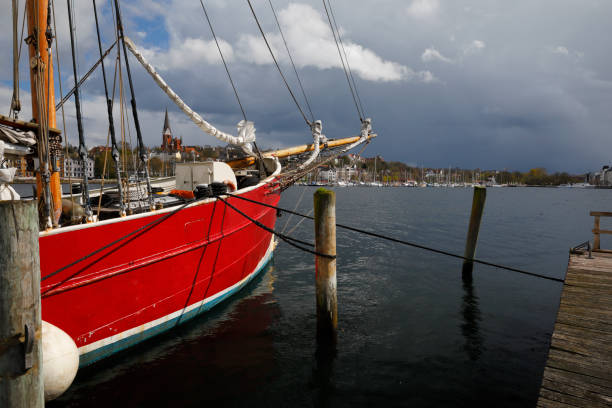 Flensburg Harbor, Germany Historic sailing boat at the harbor of Flensburg, Germany. Dramatic clouds in April. Photography taken with polarizing filter. gewitter stock pictures, royalty-free photos & images