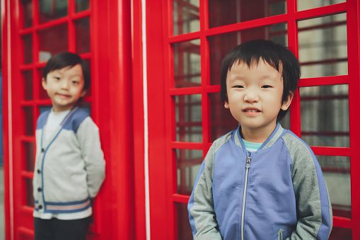 Children with red telephone box in the city