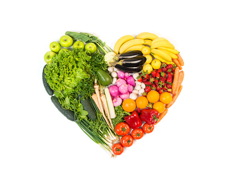 Heart made out of fruits and vegetables isolated on white background