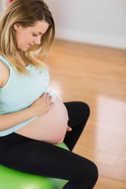 istock Pregnant woman sitting on exercise ball 670324612