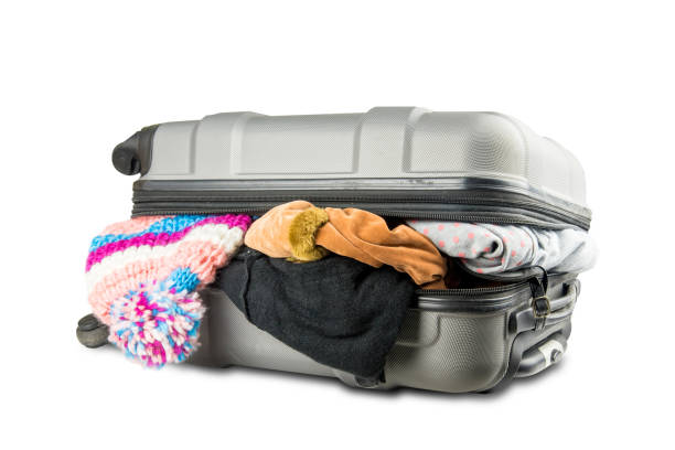 istock full suitcase with clothes on white background. 670337260