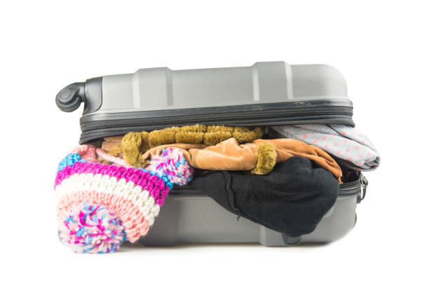 istock full suitcase with clothes on white background. 670337354
