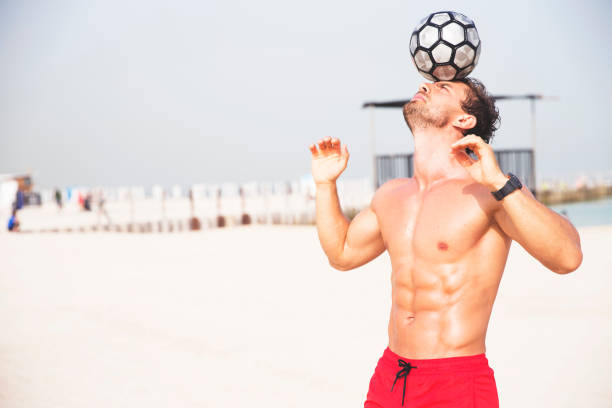istock Man playing with a football at the beach 670337708