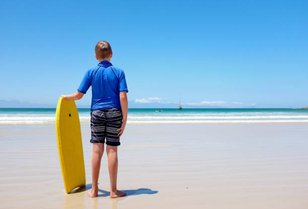 istock Frustrated boy with bodyboard by ocean with no surf 670345718