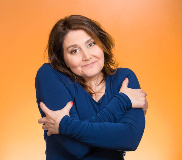 istock happy smiling woman, holding, hugging herself 670358774