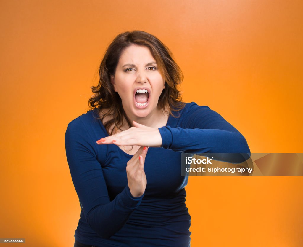 middle aged screaming woman, showing time out gesture with hands, Closeup portrait middle aged screaming woman, showing time out gesture with hands, isolated orange background. Negative human emotions, facial expressions, sign symbols, body language, attitude, reaction Adult Stock Photo
