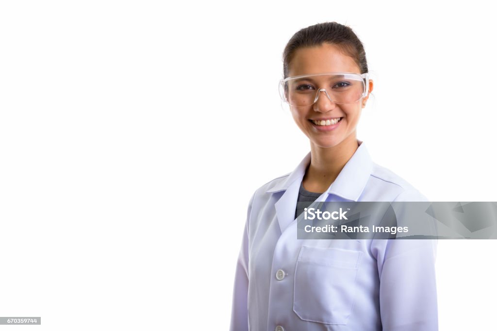 Studio shot of young happy woman doctor smiling while wearing protective glasses Studio shot of young happy woman doctor smiling while wearing protective glasses horizontal shot Scientist Stock Photo