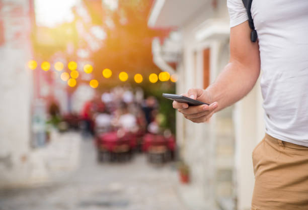 Man using mobile smart phone outdoor in summer.